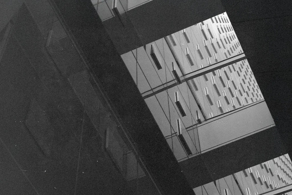 Geometric architectural reflection showing repeating window patterns on mirrored building panels