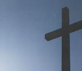 A large cross stands against a clear blue sky