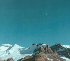 Snow‑covered mountain peaks under a clear blue sky. If you want a more keyword‑rich version (faith, stren