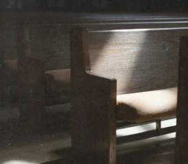 Sunlight illuminating wooden church pews in a quiet sanctuary