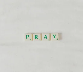 Green Scrabble pieces that spell "PRAY"