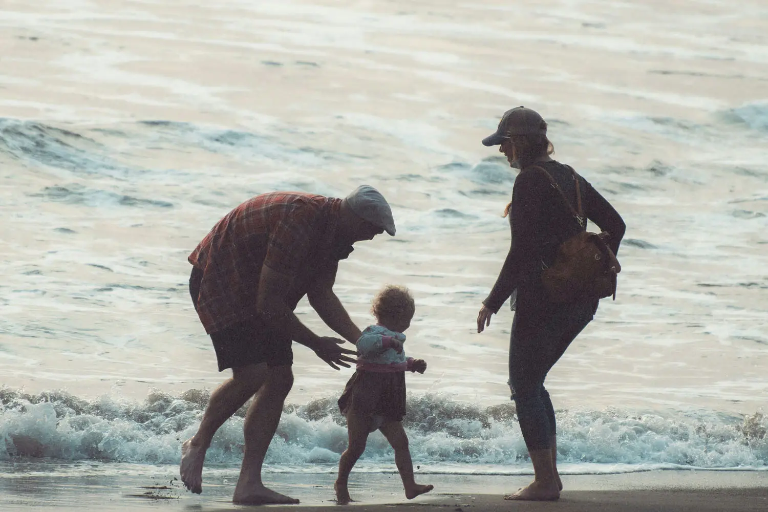 Grandparents playing with grandchild at the beach