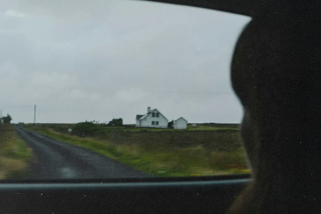 Girl looking out of car window into a field