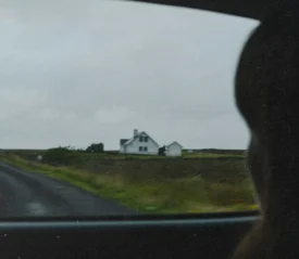 Girl looking out of car window into a field
