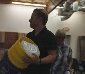 Riley Stephenson carrying a stack of buckets