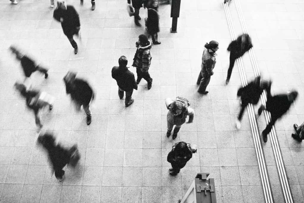Black and white, blurred, aerial view of crowd of people walking