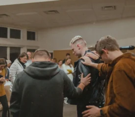 group of people praying with heads down