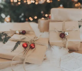 brown paper wrapped gifts under a christmas tree