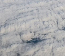 Shot of clouds from above with small town peeking through