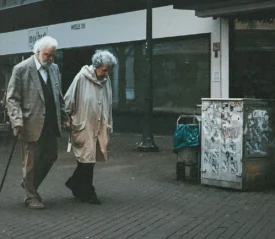 Elderly couple holding hands walking down the street