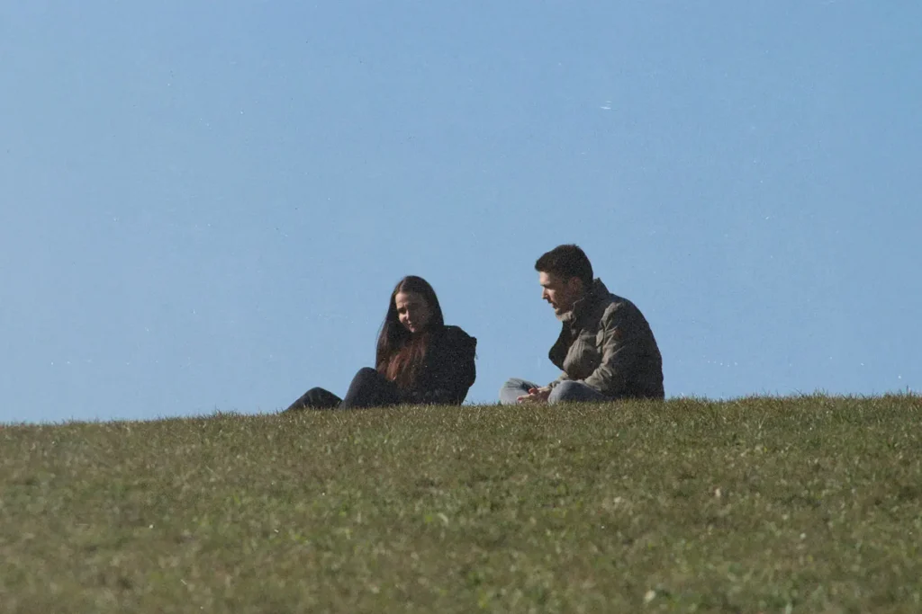 Couple sitting on a hill in the grass