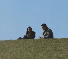 Couple sitting on a hill in the grass