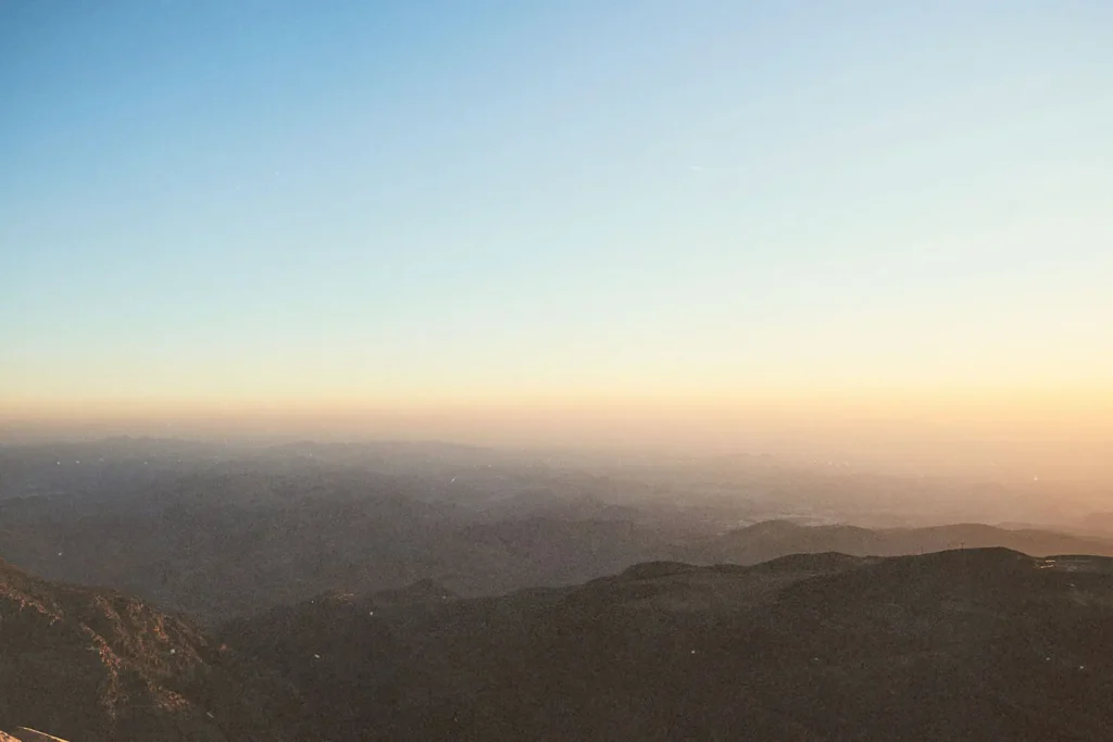 Sunrise casting warm light over distant mountain ridges