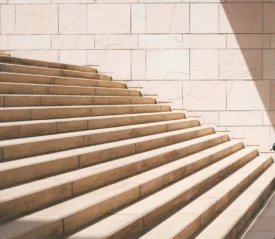 light tan stairway on a stone wall