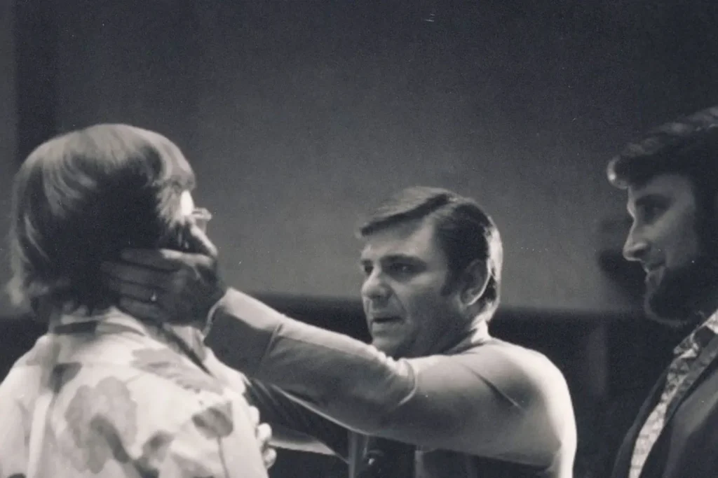 Kenneth Copeland praying and laying hands on man's jaw