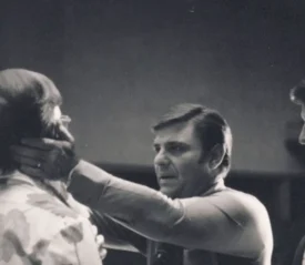 Kenneth Copeland praying and laying hands on man's jaw