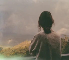 women looking off the balcony at lush mountains