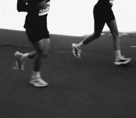 black and white photo of two people running in a marathon