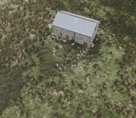 birdseye view of a building in the middle of a lush field