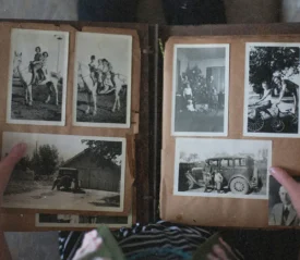 person looking through a vintage photo book of black and white photos