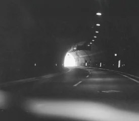 Car driving through a dimly lit tunnel