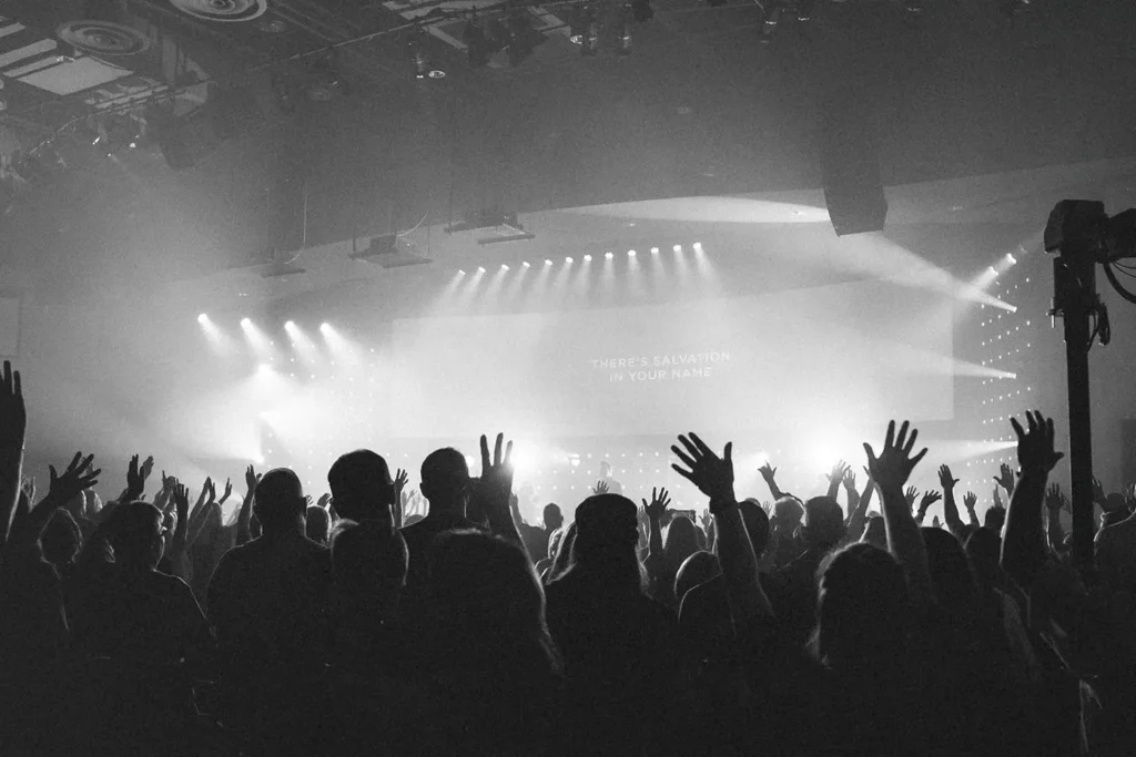 black and white photo of a crowd of people with hands in the air