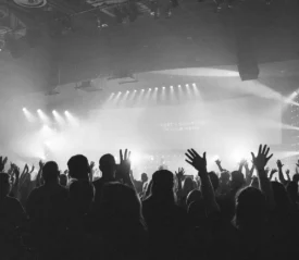 black and white photo of a crowd of people with hands in the air