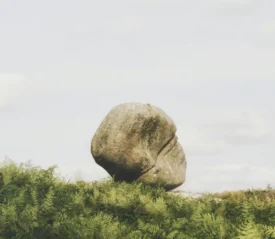 rock boulder on top of grassy hill