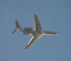 Airplane flying through cloudless blue sky