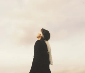 woman looking up with a cloudy background