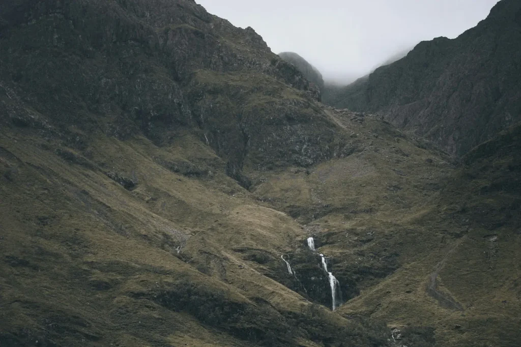 small waterfall in the middle of a mountain range