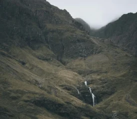 small waterfall in the middle of a mountain range