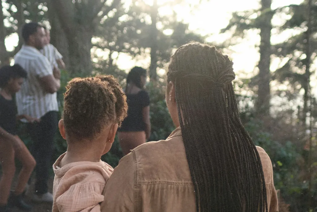 women carrying a child walking toward more people