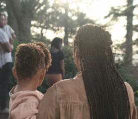 women carrying a child walking toward more people