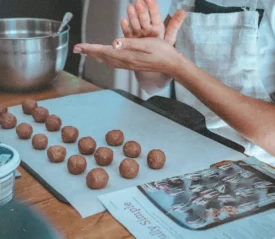 Girl in the kitchen preparing cookies to be baked, representing Ways to Give This Christmas that aren't money