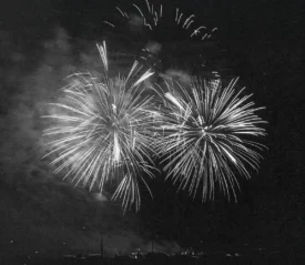 Black and white image of sky full of fireworks