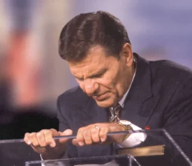 Kenneth Copeland praying at a podium