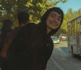 Young boy in dark hoodie smiling
