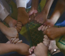 Group of hands holding to form a circle