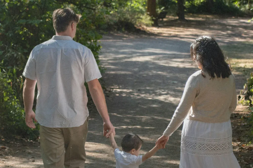 Family of three walking down a path