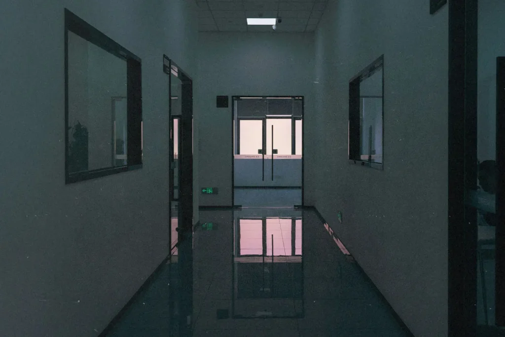 Dimly lit hallway of hospital leading to the front desk