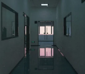 Dimly lit hallway of hospital leading to the front desk