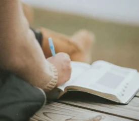 Person writing in their Bible