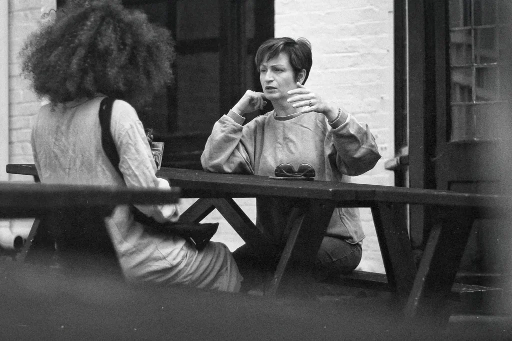 Two women talking at a picnic table