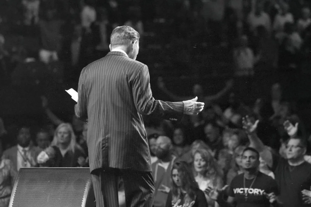 Back of Kenneth Copeland preaching to an audience