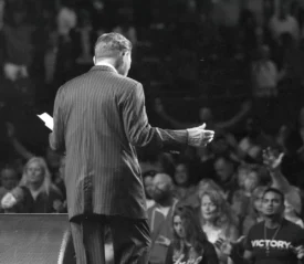 Back of Kenneth Copeland preaching to an audience