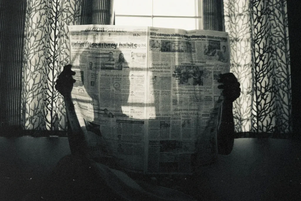 Silhouette of person holding a newspaper