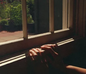 Two hands grasping a window seal