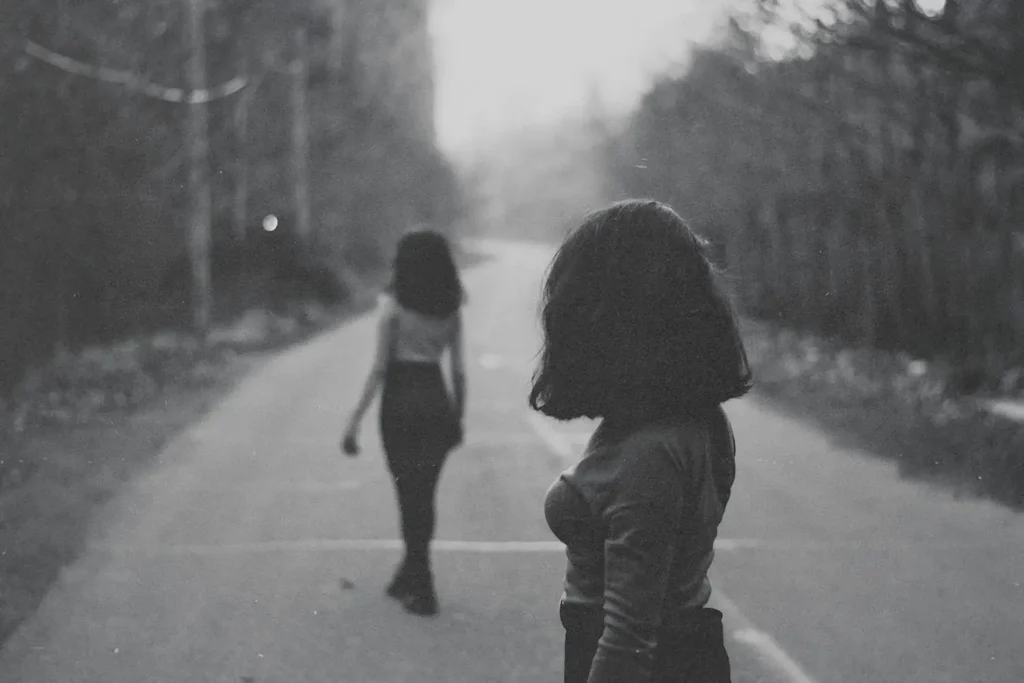 Young woman walking away from another woman