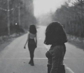 Young woman walking away from another woman